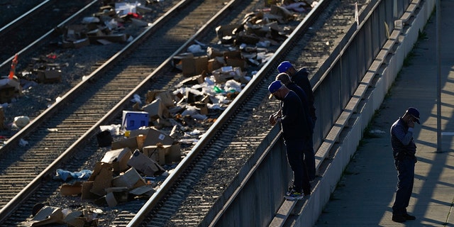 Men look over a railing at a Union Pacific railroad site on Thursday, Jan. 20, 2022, in Los Angeles. (AP Photo/Ashley Landis)