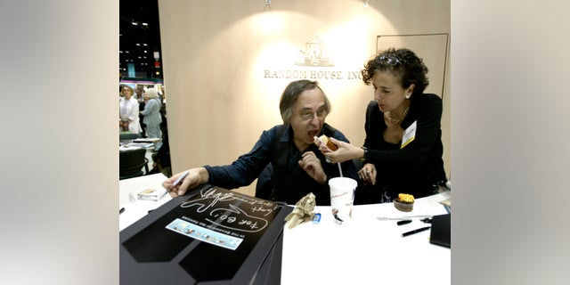 Artist and author Art Spiegelman gets some help with his lunch from Francoise Mouly, of Random House, Inc., during a signing of Spiegelman's new book "In the Shadow of No Towers" at the Book Expo America convention, Saturday, June 5, 2004, in Chicago. 