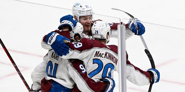 Colorado Avalanche center Nathan MacKinnon (29) celebrates with center Nazem Kadri (91) and right wing Valeri Nichushkin (13) after McKinnon scored a goal against the Nashville Predators during the third period Tuesday, Jan. 11, 2022, in Nashville. The Predators won in overtime 5-4.