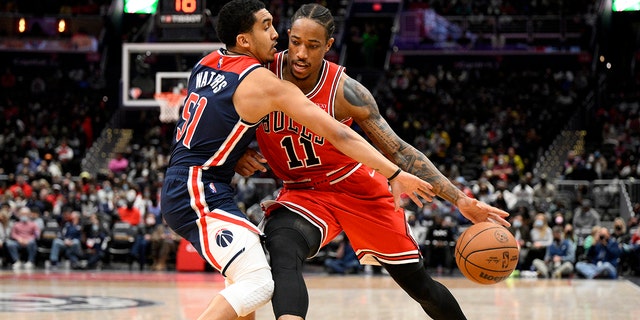 Chicago Bulls forward DeMar DeRozan (11) drives to the basket against Washington Wizards guard Tremont Waters (51) during the first half of an NBA basketball game, Saturday, Jan. 1, 2022, in Washington.