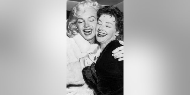 Marilyn Monroe, (L) is hugging her sister-in-law, Joan Copeland (1922 - 2022), at a party in the Barbizon Plaza Hotel to celebrate the latter's opening in the Noel Coward Play, Conversation Piece. Joan is a sister of Marilyn's husband, playwright Arthur Miller.