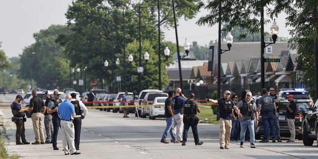 Police officers investigate a crime scene near the border between the Morgan Park and West Pullman neighborhoods on July 7, 2021 in Chicago, Illinois. Two ATF agents and one Chicago Police officer were shot as they worked undercover. (Photo by Kamil Krzaczynski/Getty Images) 