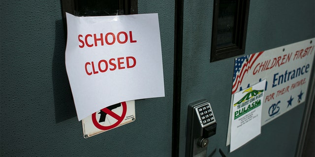 A sign taped to the front door of the Pulaski International School of Chicago after Chicago Public Schools, the nation's third-largest school district, said it would cancel classes since the teachers' union voted in favor of a return to remote learning in early January 2022.  