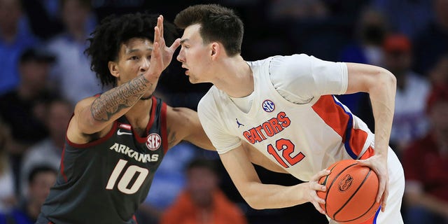 Arkansas forward Jaylin Williams (10) defends against Florida forward Colin Castleton (12) during the first half of an NCAA college basketball game Tuesday, Feb. 22, 2022, in Gainesville, Fla.