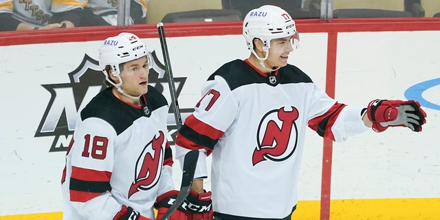 New Jersey Devils' Yegor Sharangovich, right, celebrates beside teammate Dawson Mercer (18) after scoring against the Pittsburgh Penguins during the first period of an NHL hockey game, Thursday, Feb. 24, 2022, in Pittsburgh. 