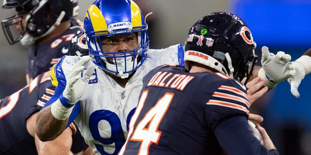 FILE- In this Sunday, Sept. 12, 2021, file photo, Los Angeles Rams defensive end Aaron Donald (99) tackles Chicago Bears quarterback Andy Dalton (14) during an NFL football game in Inglewood, Calif. As Donald, now 30, closes in on the franchise's career sacks record this week, the three-time NFL Defensive Player of the Year says the only difference in his game with age is the recovery time necessary for minor injuries.  (AP Photo/Kyusung Gong, File)