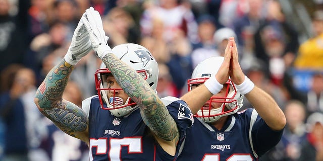 Cassius Marsh #55 and Trevor Reilly #49 of the New England Patriots signal for a safety during the second quarter of a game against the Los Angeles Chargers at Gillette Stadium on Oct. 29, 2017, in Foxboro, Massachusetts.