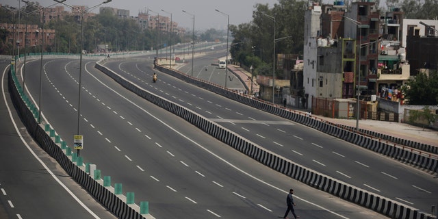 A man crosses an empty expressway during a complete lockdown amid growing concerns of coronavirus on March 24, 2020.
