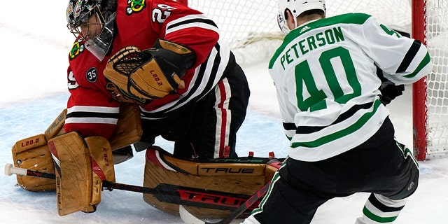 Chicago Blackhawks goaltender Marc-Andre Fleury, left, gives up a goal to Dallas Stars center Jacob Peterson during the shootout in an NHL hockey game in Chicago, Friday, Feb. 18, 2022. The Stars won 1-0.