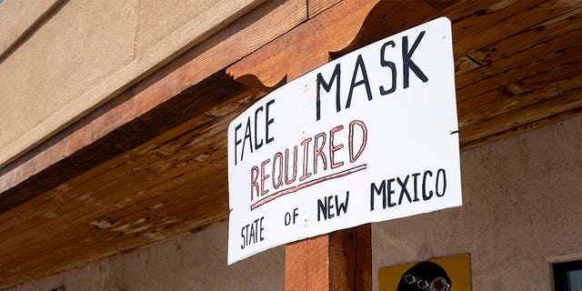 Face masks required signs are posted outside the Indian Village Gift Shop in Continental Divide, N.M.