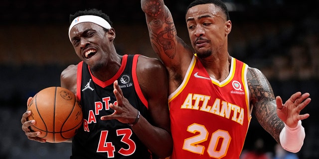 Toronto Raptors forward Pascal Siakam (43) protects the ball from Atlanta Hawks forward John Collins (20) during the first half of an NBA basketball game Friday, Feb. 4, 2022, in Toronto.