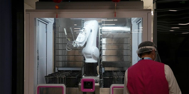 A robot prepares food in the media dining area of the main media center ahead of the 2022 Winter Olympics, Wednesday, Feb. 2, 2022, in Beijing. 