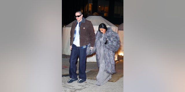 Kardashian, 41, wore a shimming fringe coat with a silver dress and metallic boots, Davidson, 28, kept his look more casual with baggy jeans and a flannel shirt.