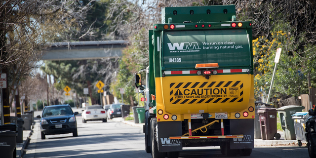 A Waste Management Inc. garbage collection truck drives through a neighborhood in Hayward, California, U.S., on Monday, Feb. 12, 2018. 