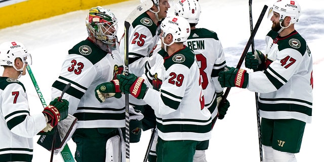 Minnesota Wild goaltender Cam Talbot (33) celebrates with teammates after the Wild defeated the Chicago Blackhawks 5-0 in an NHL hockey game in Chicago, Wednesday, Feb. 2, 2022.