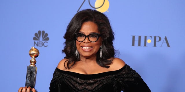 Oprah Winfrey poses backstage with her Cecil B. DeMille Award.