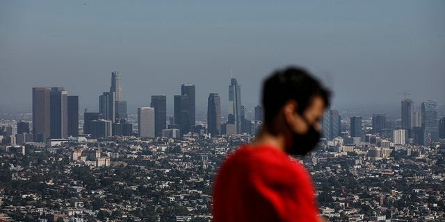 Izzy Galvan, 20, wears a face mask while visiting the Griffith Observatory overlooking downtown Los Angeles on July 15, 2020. (AP Photo/Jae C. Hong)
