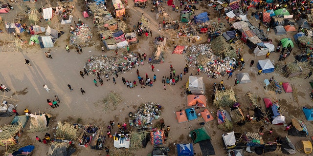 Migrants, many from Haiti, are seen at an encampment along the Del Rio International Bridge near the Rio Grande.