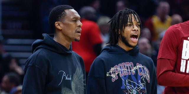 Injured Cleveland Cavaliers guards Rajon Rondo, left, and Darius Garland cheer for teammates during the first half of the team's NBA basketball game against the Minnesota Timberwolves, Monday, Feb. 28, 2022, in Cleveland.