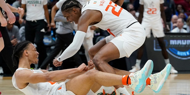 Miami's Isaiah Wong is congratulated by Kameron McGusty (23) after making a shot and being fouled during the second half of a college basketball game in the Sweet 16 round of the NCAA tournament Friday, March 25, 2022, in Chicago. 