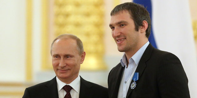 Vladimir Putin and Alexander Ovechkin pose in the Kremlin on May 27, 2014, during a reception for the national team that won the ice hockey world championship that year.