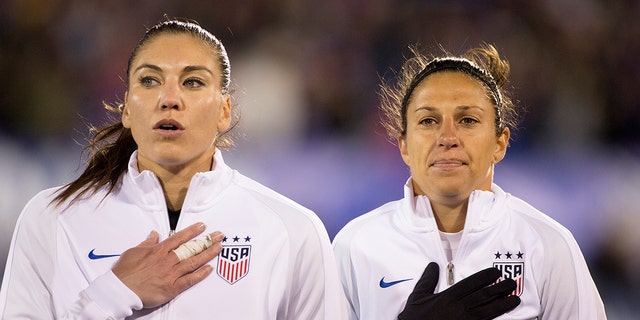 USA goalkeeper Hope Solo (left), and teammate Carli Lloyd during team national anthems before the USA vs. Colombia Women's International friendly football match at the Pratt &amp; Whitney Stadium on April 6, 2016, in East Hartford, Connecticut. 