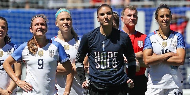 (L-R) Heather O'Reilly #9, Julie Johnson #8, Hope Solo #1 and Carli Lloyd #10 of the United States watch a video tribute to Solo after she posted her 100th career shutout against South Africa in a friendly match at Soldier Field on July 9, 2016, in Chicago, Illinois. The United States defeated South Africa 1-0.