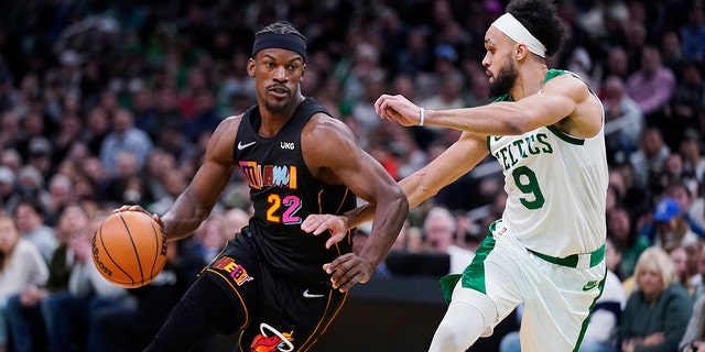 Miami Heat forward Jimmy Butler (22) drives to the basket against Boston Celtics guard Derrick White (9) during the second half of an NBA basketball game Wednesday, March 30, 2022, in Boston.