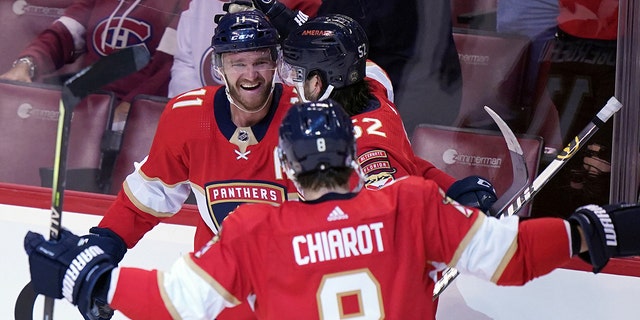 Florida Panthers left wing Jonathan Huberdeau (11) celebrates a goal with teammates defenseman MacKenzie Weegar (52) and defenseman Ben Chiarot (8) during the first period of an NHL hockey game against the Montreal Canadiens Tuesday, March 29, 2022, in Sunrise, Fla.