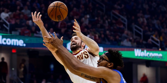 Cleveland Cavaliers' Kevin Love, left, grabs a rebound against Orlando Magic's Wendell Carter Jr., right, during the first half of an NBA basketball game, Monday, March 28, 2022, in Cleveland.
