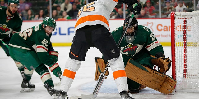Minnesota Wild defenseman Jared Spurgeon (46) pokes the puck away form Philadelphia Flyers left wing James van Riemsdyk (25) with Minnesota Wild goaltender Marc-Andre Fleury (29) looks on in the second period of an NHL hockey game Tuesday, March 29, 2022, in St. Paul, Minn.