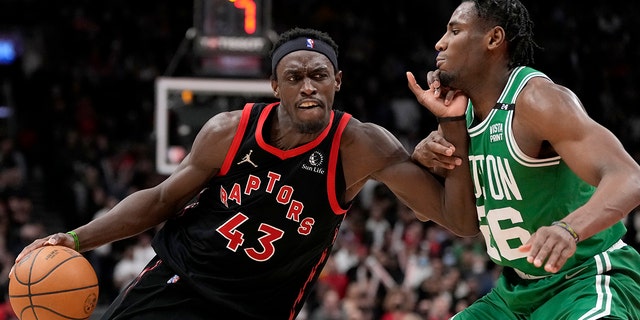 Toronto Raptors forward Pascal Siakam (43) drives past Boston Celtics forward Aaron Nesmith (26) during second-half NBA basketball game action in Toronto, Monday, March 28, 2022.