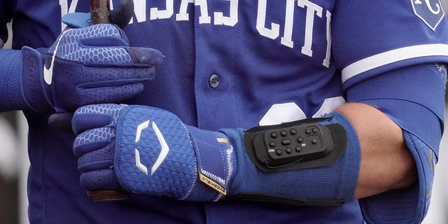 Kansas City Royals catcher Cam Gallagher wears a wrist-worn device used to call pitches as he prepares to bat during the sixth inning of a spring training game against the Seattle Mariners March 29, 2022, in Peoria, Ariz.