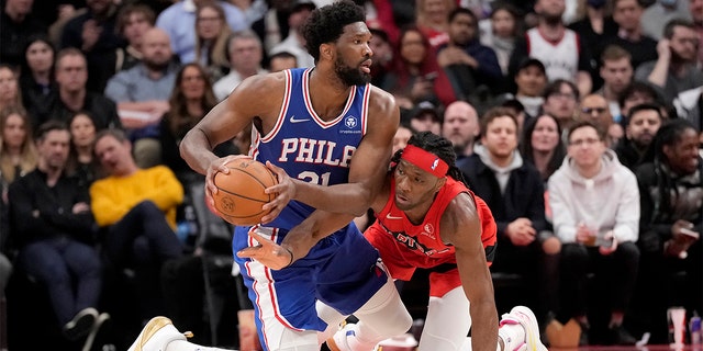 Raptors forward Precious Achiuwa tries to steal the ball from Philadelphia 76ers center Joel Embiid on April 7, 2022, in Toronto.
