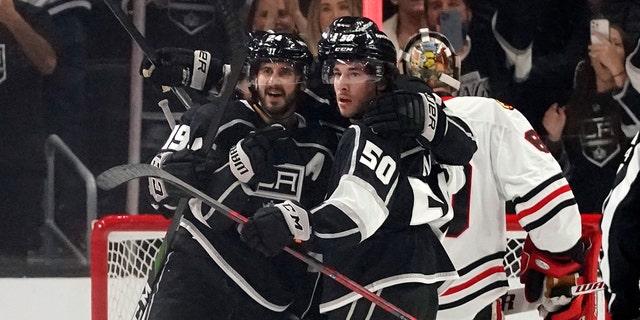 Los Angeles Kings center Phillip Danault (24) is hugged by teammates after scoring against the Chicago Blackhawks during the first period of an NHL hockey game Thursday, April 21, 2022, in Los Angeles. 