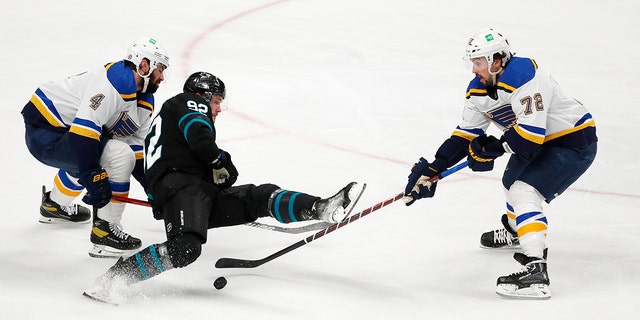 St. Louis Blues defenseman Nick Leddy, left, and defenseman Justin Faulk, right, compete for the puck against San Jose Sharks left wing Rudolfs Balcers (92) during the second period of an NHL hockey game in San Jose, Calif., Thursday, April 21, 2022. 