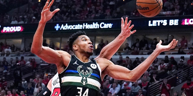 Milwaukee Bucks forward Giannis Antetokounmpo (34) battles for a rebound against Chicago Bulls center Nikola Vucevic during the first half of Game 3 of a first-round NBA basketball playoff series Friday, April 22, 2022, in Chicago. 