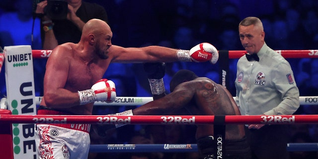 Britain's Tyson Fury, left, aims a blow at Britain's Dillian Whyte during their WBC heavyweight title boxing fight at Wembley Stadium in London, Saturday, April 23, 2022. (AP Photo/Ian Walton)
