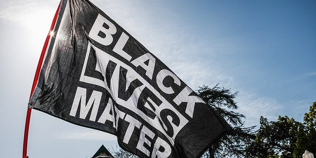 LOS ANGELES, CALIFORNIA, UNITED STATES - 2021/04/20: A protester waves a Black Lives Matter flag during the demonstration. Hours after the verdict of the Derek Chauvin trial, protesters meet outside of Los Angeles Mayor Eric Garcetti's home to protest his proposed funding of the Los Angeles Police Department. (Photo by Stanton Sharpe/SOPA Images/LightRocket via Getty Images)