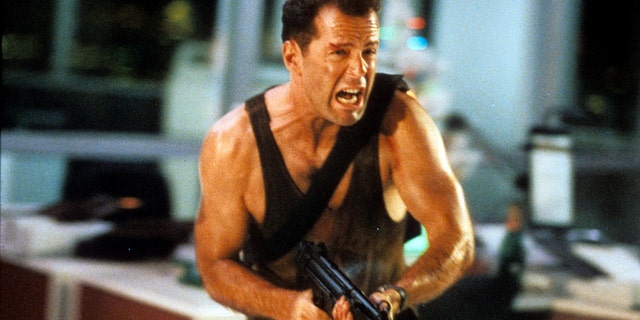 Bruce Willis running with automatic weapon in a scene from the film "Die Hard", 1988. The actor's family announced this week he is "stepping away" from acting after being diagnosed with aphasia, a condition that causes loss of the ability to understand or express speech.