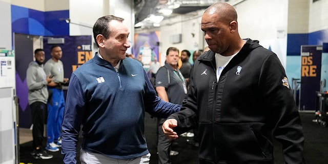 Duke coach Mike Krzyzewski, left, and North Carolina coach Hubert Davis make their way to an interview at the men's Final Four March 31, 2022, in New Orleans. Duke plays North Carolina Saturday.