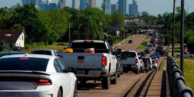 Cars are lined up in traffic on Airline Drive after a food distribution site at Reyes Produce opened on April 13, 2020, in Houston, Texas. (Photo by Mark Felix/AFP via Getty Images)