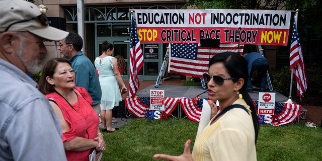 People talk before the start of a rally against "critical race theory" (CRT) being taught in schools at the Loudoun County Government center in Leesburg, Virginia on June 12, 2021. 