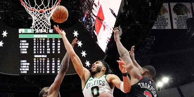 Boston Celtics forward Jayson Tatum (0) drives to the basket against Chicago Bulls forward Patrick Williams, left, and center Tristan Thompson during the second half of an NBA basketball game in Chicago, Wednesday, April 6, 2022. The Celtics won 117-94.
