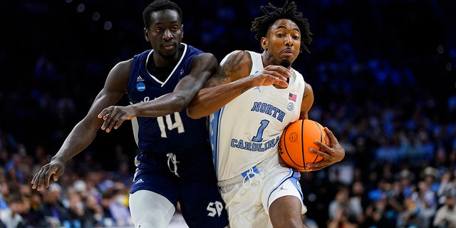 North Carolina's Leaky Black, right, tries to get past St. Peter's Hassan Drame during the Elite Eight of the NCAA tournament March 27, 2022, in Philadelphia.