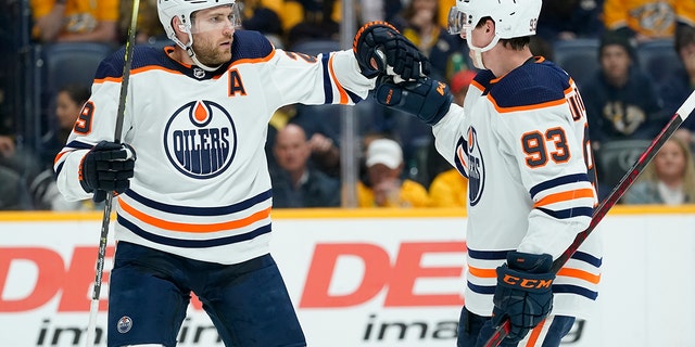 Edmonton Oilers' Leon Draisaitl (29) is congratulated by Ryan Nugent-Hopkins (93) after Draisaitl scored a goal against the Nashville Predators in the first period of an NHL hockey game Thursday, April 14, 2022, in Nashville, Tenn.