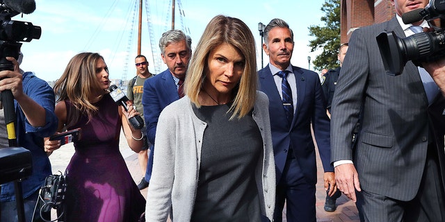 Lori Loughlin, center, and her husband Mossimo Giannulli, behind her at right, leave the John Joseph Moakley United States Courthouse in Boston Aug. 27, 2019. 