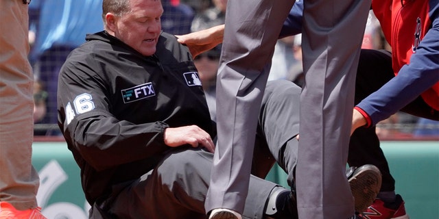 Home plate umpire Ron Kulpa is tended to after being hit with a foul ball during the fourth inning of a game between the Boston Red Sox and the Chicago White Sox at Fenway Park, Sunday, May 8, 2022, in Boston.
