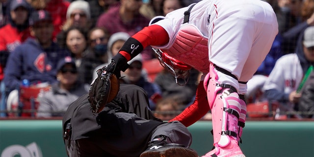 Boston Red Sox catcher Christian Vazquez checks on home plate umpire Ron Kulpa after Kulpa was hit with a foul ball during the fourth inning a game between the Boston Red Sox and the Chicago White Sox at Fenway Park, Sunday, May 8, 2022, in Boston. 