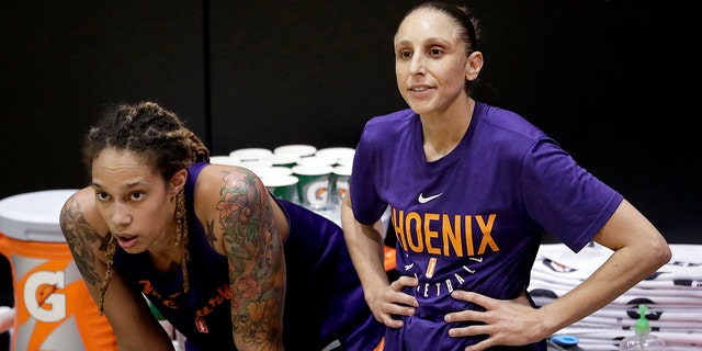 FILE - Phoenix Mercury's Brittney Griner, left, watches practice with teammate Diana Taurasi on Thursday, May 10, 2018, in Phoenix.
